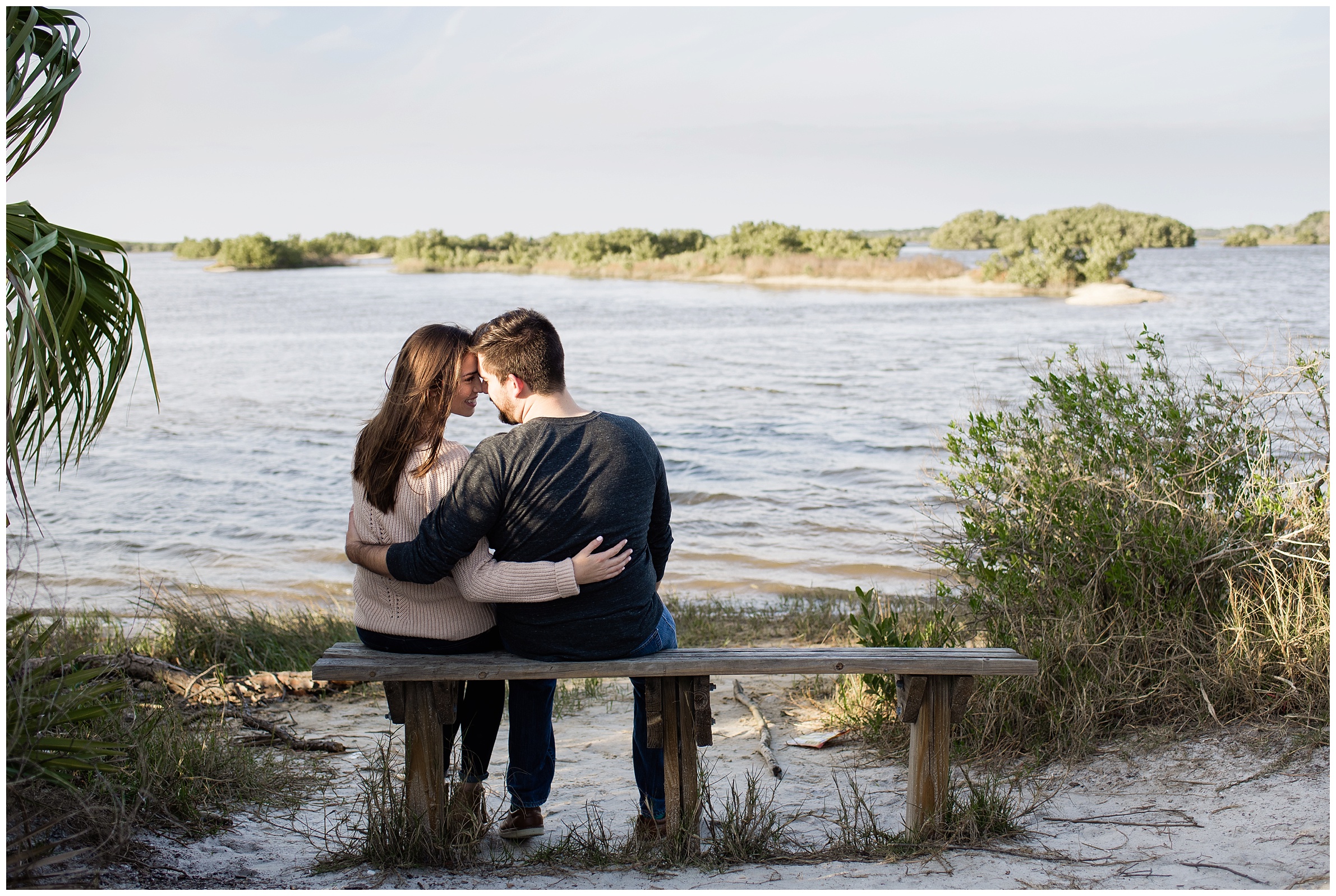 couple sitting on bench by water