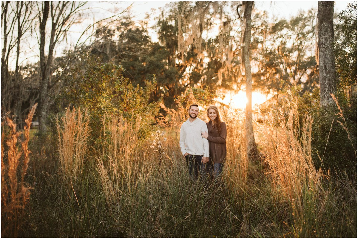 couple hold hands in tall grass sunny 